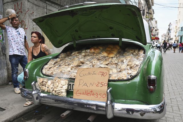 Vendors wait for customers at the trunk of their American classic car carrying homemade baked goods in Havana, Cuba, Tuesday, July 15, 2025. (Photo by Jorge Luis Baños/AP Photo)