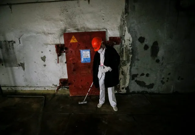 An employee measures the radiation level near a damaged fourth reactor at the Chernobyl nuclear power plant in Chernobyl, Ukraine April 20, 2018. (Photo by Gleb Garanich/Reuters)