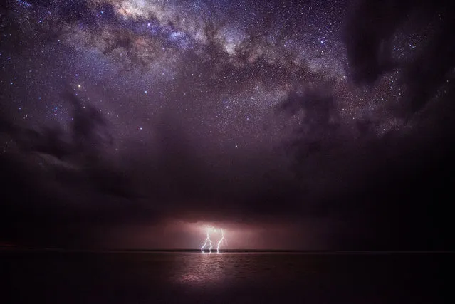 Calm Before the Storm. A phenomenal natural light show of a lightning storm emanating from the underside of ominous storm clouds, juxtaposed with the gleaming stars of the Milky Way above. (Photo by Julie Fletcher)