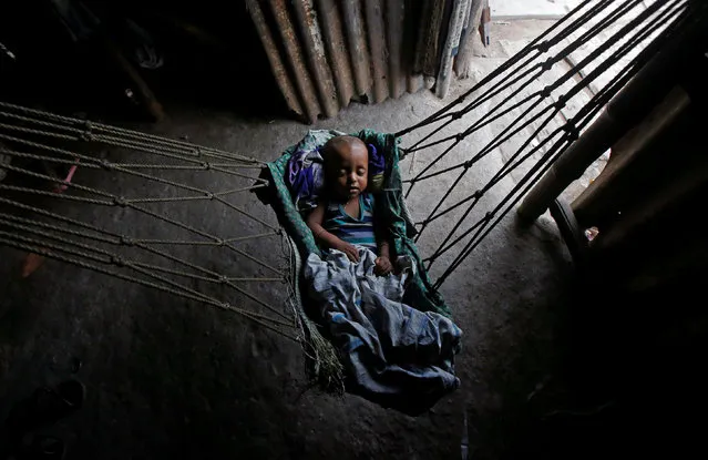 An infant sleeps in a hammock at a makeshift shelter in Kolkata, India, April 23, 2018. (Photo by Rupak De Chowdhuri/Reuters)