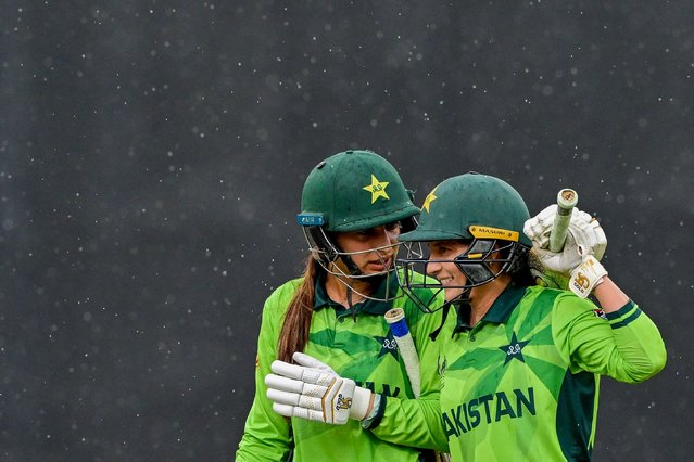 Pakistan's Aliya Riaz (L) and Natalia Pervaiz walk off the field as rain stops play during the ICC Women's Cricket World Cup 2025 one-day international (ODI) match between New Zealand and Pakistan at the R. Premadasa International Cricket Stadium in Colombo on October 18, 2025. (Photo by Ishara S. Kodikara/AFP Photo)