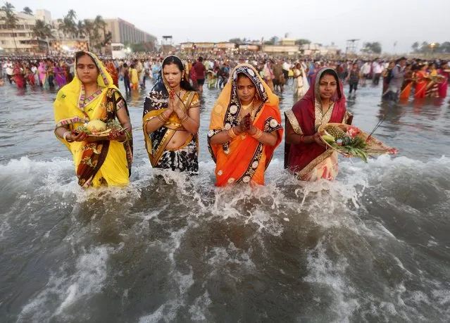 Hindu women worship the Sun god Surya while standing in the waters of the Arabian Sea during the Hindu religious festival of Chatt Puja in Mumbai, India, November 17, 2015. (Photo by Shailesh Andrade/Reuters)