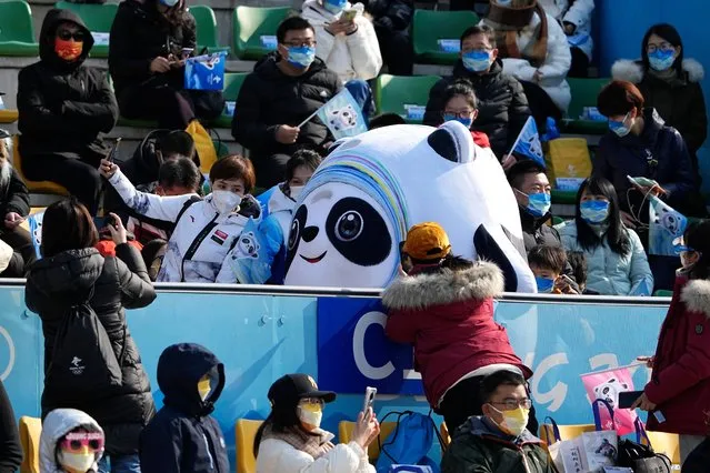 The Olympic mascot Bing Dwen Dwen poses with spectators during the men's freestyle skiing big air finals of the 2022 Winter Olympics, Wednesday, February 9, 2022, in Beijing. (Photo by Jae C. Hong/AP Photo)