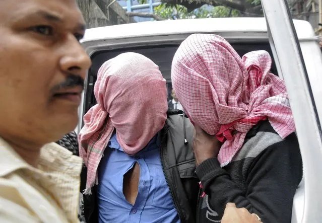 A plain-clothes policeman (L) escorts two men who were arrested in connection with the alleged abduction and gang-rape of a Japanese tourist, outside a court in Kolkata January 3, 2015. Indian police have arrested five men in connection with the alleged abduction and gang-rape of a 23-year-old Japanese tourist, officials said on Saturday. (Photo by Reuters/Stringer)