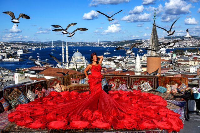 A tourist looks out towards the Bosphorus as she poses for a photograph in an open-air studio terrace, in Istanbul on September 18, 2025. (Photo by Yasin Akgul/AFP Photo)