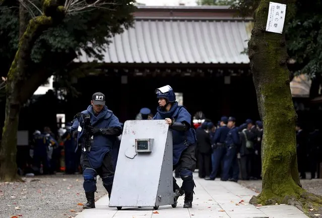 Members of a police bomb disposal squad move a blast protection device near the site of an explosion at the Yasukuni shrine in Tokyo, Japan, November 23, 2015. (Photo by Toru Hanai/Reuters)