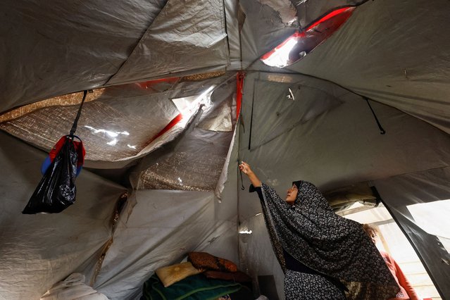 A displaced Palestinian woman shows her torn tent, amid a ceasefire between Israel and Hamas, in Gaza City, on November 4, 2025. (Photo by Mahmoud Issa/Reuters)