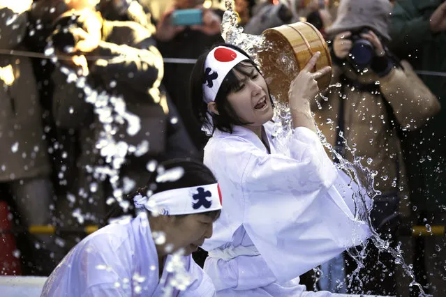 Shrine parishioners using a wooden tub pour cold water onto themselves during an annual cold-endurance festival at the Kanda Myojin Shinto shrine in Tokyo, Saturday, January 10, 2015. (Photo by Eugene Hoshiko/AP Photo)