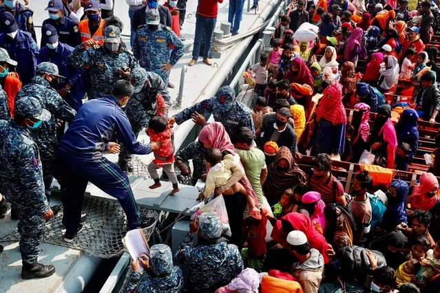 Rohingyas refugees get off from a navy vessel as they arrive at the Bhasan Char island in Noakhali district, Bangladesh, December 29, 2020. Bangladesh moved a second group of Rohingya Muslim refugees to a low-lying island in the Bay of Bengal, despite opposition from rights groups worried about the new site’s vulnerability to storms. (Photo by Mohammad Ponir Hossain/Reuters)