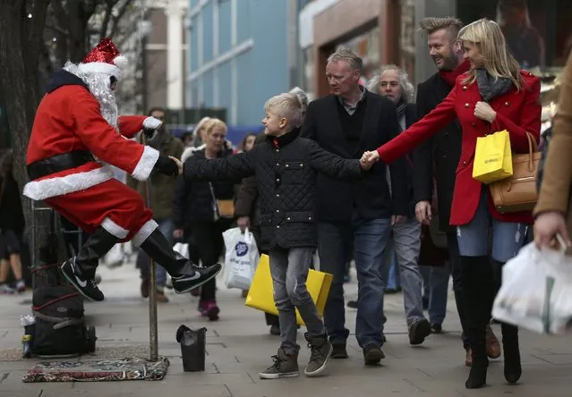 A street performer dressed as Santa Claus interacts with shoppers on Oxford Street in London, Britain, December 5, 2015. (Photo by Neil Hall/Reuters)