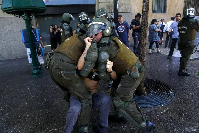 A demonstrator is detained by riot policemen during a protest against the private system of pension fund administrators in Santiago, Chile, December 10, 2015. (Photo by Ivan Alvarado/Reuters)