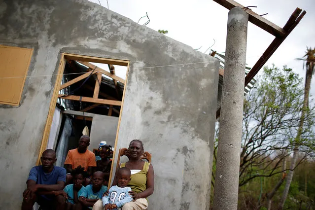 Matha Dominique (R), 67, poses for a photograph with her relatives at their destroyed house after Hurricane Matthew hit Jeremie, Haiti, October 19, 2016. “I thought that it was the end of the world. I lost everything, my crops, my animals – things that took many years to build, disappeared in few minutes. At my age, do you think that I could do something or start again, I think not.  God is accountable for my situation, should I thank him for having done this to me?” said Dominique. (Photo by Carlos Garcia Rawlins/Reuters)