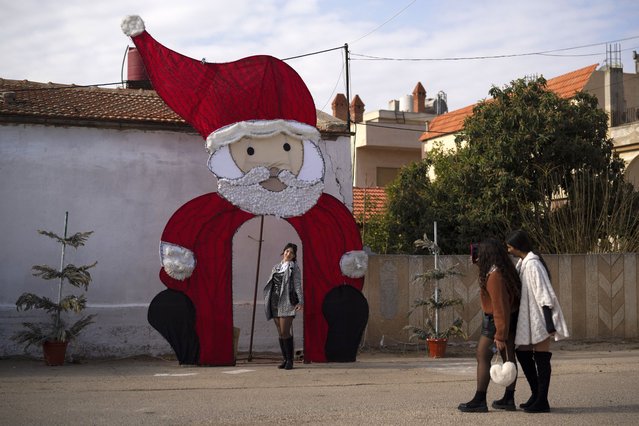 A young woman poses for a picture with a Christmas decoration on a square in a Christian neighbourhood, in Homs, Syria, Thursday, December 26, 2024. (Photo by Leo Correa/AP Photo)