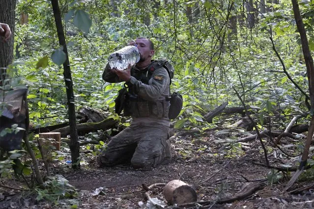 A Ukrainian soldier drinks water on the frontline near Kreminna, Luhansk region, Ukraine, Thursday, June 8, 2023. (Photo by Roman Chop via AP Photo)