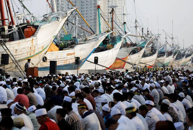 Muslims attend prayers to celebrate Eid al-Fitr at Sunda Kelapa port in Jakarta, Indonesia June 15, 2018. (Photo by Darren Whiteside/Reuters)
