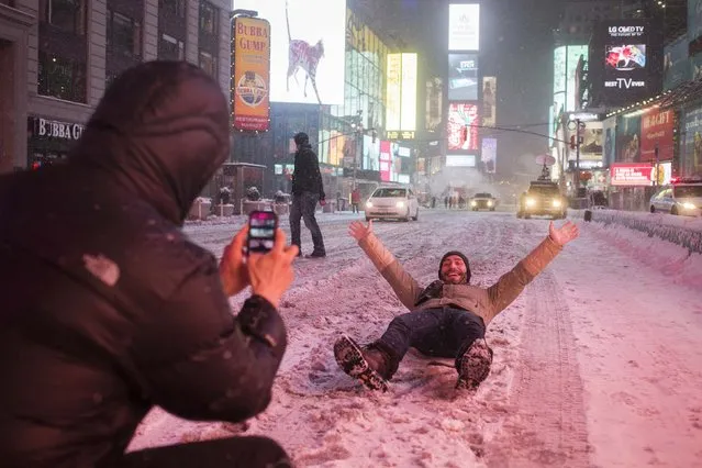 Valentin Borriello, from Paris, France, has his photograph made by a friend while lying on 7th Ave during snow storm in Times Square, New York early morning January 26, 2015. A life-threatening blizzard barreled into the U.S. Northeast, affecting up to 20 percent of Americans by making workers and students housebound, halting thousands of flights and prompting New York to ban cars from roads and halt subway trains. (Photo by Adrees Latif/Reuters)