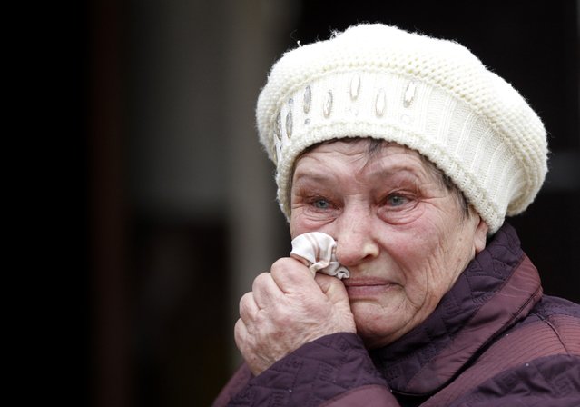 A woman wipes a tear outside of her home in the town of Svitlodarsk, Ukraine, Friday, January 30, 2015. Shelling of the town Thursday, which destroyed the local hospital, has damaged basic infrastructure, cutting off electricity, water and household gas supplies. Fighting is raging nearby between government and Russian-backed separatists for control of the railway hub in the town of Debaltseve. (Photo by Petr David Josek/AP Photo)