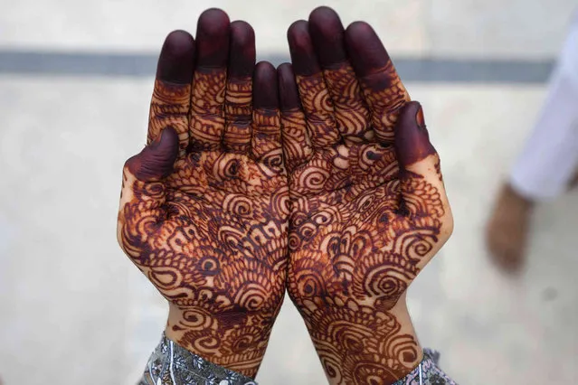 A Muslim, her hands decorated with henna, offers Eid al-Adha prayers at Jami Masjid in Ahmedabad, India, Thursday, June 29, 2023. Muslims around the world celebrate Eid al-Adha, or the Feast of the Sacrifice, by slaughtering sheep, goats, cows and camels to commemorate Prophet Abraham's readiness to sacrifice his son Ismail on God's command. (Photo by Ajit Solanki/AP Photo)