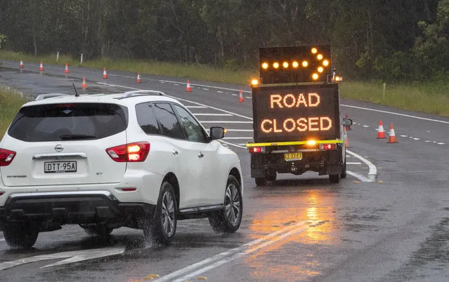A vehicle is diverted as a road is closed due to flooding on the outskirts of Port Stephens, 200 kilometers (120 miles) north of Sydney, Australia, Sunday, March 21, 2021. Residents across the state of New South Wales have been warned to prepare for possible evacuations, as NSW Premier Gladys Berejiklian said the state's flood crisis would continue for several more days. (Photo by Mark Baker/AP Photo)