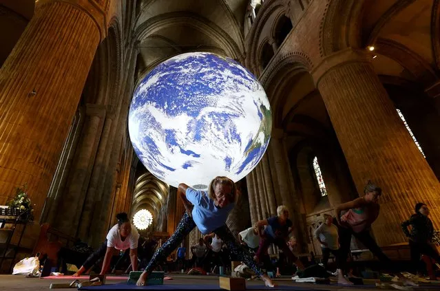 People participate in the Iyengar Yoga Class underneath Luke Jerram's Gaia artwork at Durham Cathedral in Durham, Britain on July 13, 2023. (Photo by Lee Smith/Reuters)