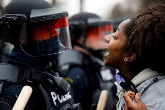 A demonstrator confronts police during a protest after police allegedly shot and killed a man, who local media report is identified by the victim's mother as Daunte Wright, in Brooklyn Center, Minnesota, U.S., April 11, 2021. (Photo by Nick Pfosi/Reuters)