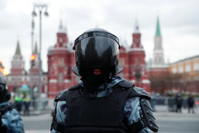 A police officer stands in front of the Kremlin during a rally in support of jailed Russian opposition politician Alexei Navalny in Moscow, Russia, April 21, 2021. (Photo by Maxim Shemetov/Reuters)