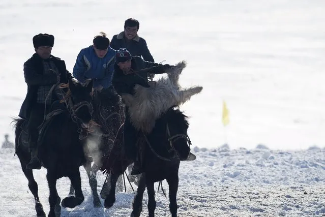 Herders ride horses as they fight for a goat during a Buzkashi game at a winter festival in Yining, Xinjiang Uighur Autonomous Region, China, January 10, 2016. (Photo by Reuters/China Daily)