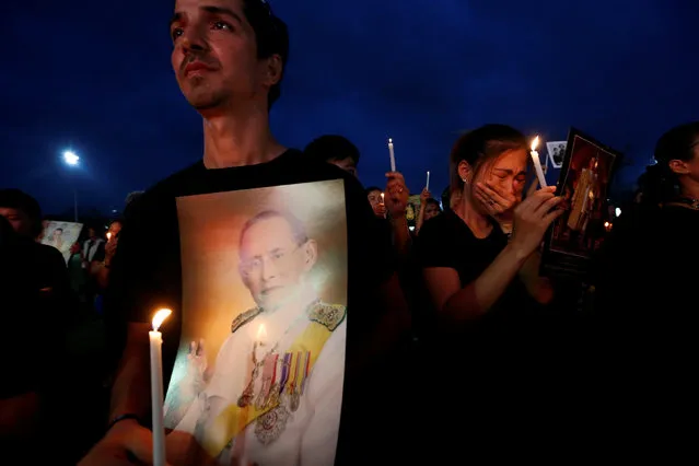 Mourners hold up pictures of Thailand's late King Bhumibol Adulyadej and candle lights during a vigil to mark his birthday outside the Grand Palace in Bangkok, Thailand, December 5, 2016. (Photo by Chaiwat Subprasom/Reuters)