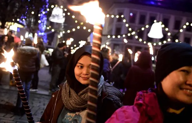 A supporter holds a torch light outside the Grand Hotel after a procession to honour the Colombian President in Oslo on December 10, 2016 President Juan Manuel Santos was awarded this year' s Nobel Peace Prize for his efforts to bring Colombias more than 50- year- long civil war to an end. (Photo by Tobias Schwarz/AFP Photo)