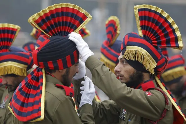 An Indian policeman adjusts his colleague's headdress during the full-dress rehearsal for the Republic Day parade in Chandigarh, India, January 22, 2016. India celebrates its annual Republic Day on January 26. (Photo by Ajay Verma/Reuters)