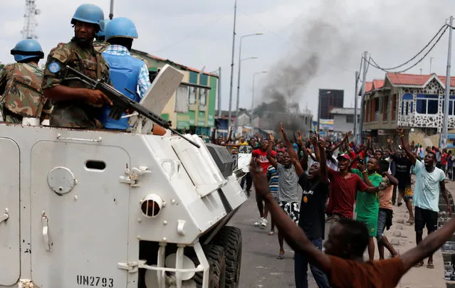 Residents chant slogans against Congolese President Joseph Kabila as peacekeepers serving in the United Nations Organization Stabilization Mission in the Democratic Republic of the Congo (MONUSCO) patrol during demonstrations in the streets of the Democratic Republic of Congo's capital Kinshasa, December 20, 2016. (Photo by Thomas Mukoya/Reuters)
