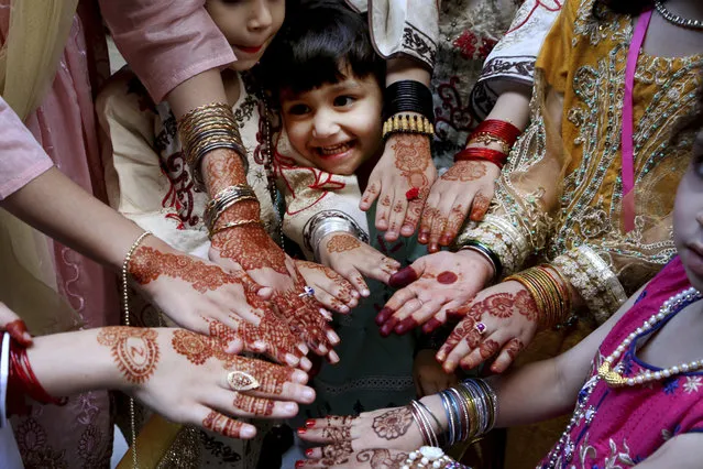 Muslims girls display their hands painted with traditional henna to celebrate Eid al-Fitr holidays, marking on the end of the fasting month of Ramadan, in Peshawar, Pakistan, Thursday, May 13, 2021. (Photo by Muhammad Sajjad/AP Photo)
