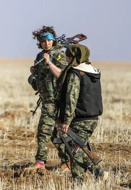 Female fighters of the Kurdish People's Protection Units (YPG) carry their weapons as they walk in the western countryside of Ras al-Ain January 25, 2015. (Photo by Rodi Said/Reuters)