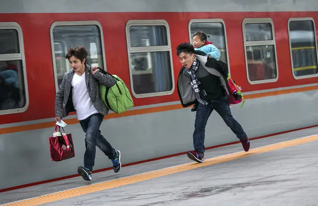Passengers run to catch a train at a railway station in Hangzhou during the travel rush ahead of the upcoming Spring Festival, Zhejiang province, January 31, 2016. (Photo by Chance Chan/Reuters)