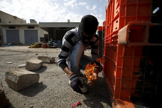 A Palestinian protester prepares a molotov cocktail to be hurled towards Israeli troops during clashes in the West Bank town of Qabatya, near Jenin February 5, 2016. (Photo by Mohamad Torokman/Reuters)