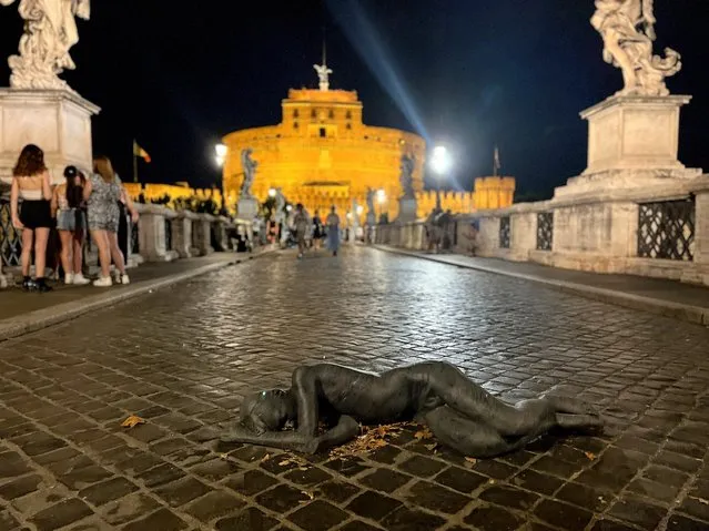 A view shows a natural-sized marble statue depicting a sleeping refugee installed by street artist Jago lying on the Sant'Angelo bridge, in Rome, Italy on August 6, 2022. (Photo by Antonio Denti/Reuters)