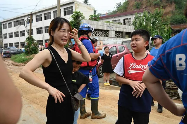 A woman and a boy cry to rescuers for help after being separated from their family members after severe flooding and landslide in recent days have hit the county-level Gongyi city, near Zhengzhou, in central Chinas Henan province on July 22, 2021. (Photo by Jade Gao/AFP Photo)