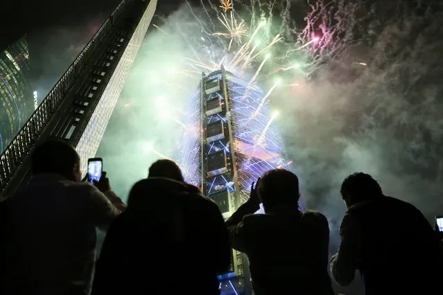 People observe fireworks inaugurating the new BBVA Bancomer headquarters in Mexico City, Mexico, 09 February 2016. The Spanish group BBVA opened in Mexico City the new corporate headquarters of its Mexican subsidiary with an investment of 650 million US dollar (574 million euro) and a structure of 21,600 tons of steel, 50 stories high, over 40 lifts and nearly 3,000 parking spaces. (Photo by Jose Mendez/EPA)