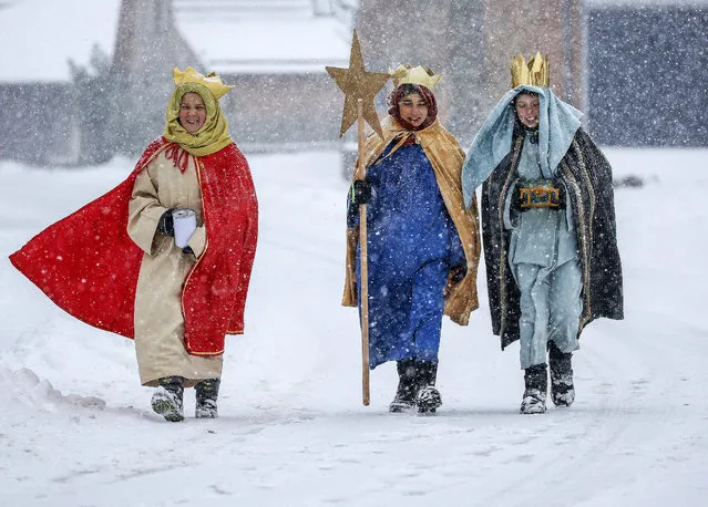Coral singer in traditional costumes walk through the snow in Eglingen, southern Germany, Saturday, January 5, 2019. (Photo by Thomas Warnack/dpa via AP Photo)