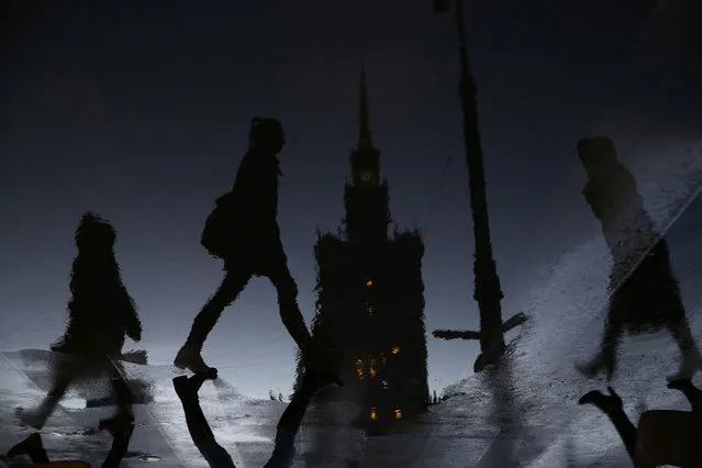 Women are reflected in a puddle as they walk in front of the Palace of Culture during rainy day in Warsaw March 4, 2015. Picture flipped 180 degrees. (Photo by Kacper Pempel/Reuters)