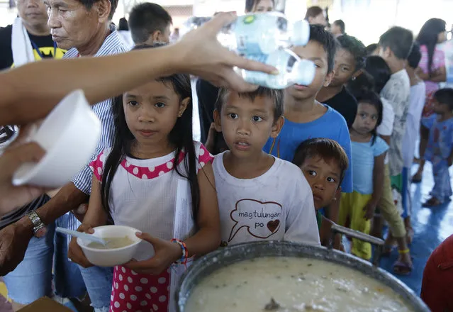 Fire victims receive a free hot meal at an evacuation centre in Muntinlupa, Metro Manila February 23, 2016. (Photo by Erik De Castro/Reuters)