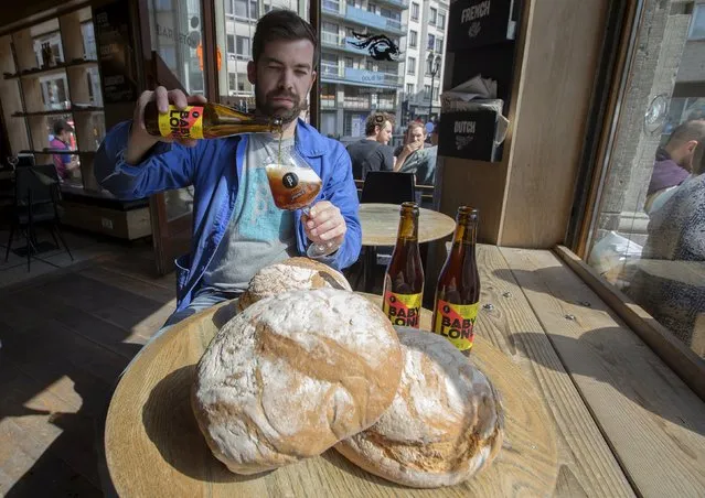 Sebastien Morvan, one of the founders of microbrewery Brussels Beer Project, displays bread and serves a beer called Babylone at Barbeton bar in central Brussels April 14, 2015. A small Brussels-based brewery has embarked on a project to make beer, the Babylone, from leftover bread, reducing a significant source of food waste and harking back to antiquity, when bread, rather than barley, was the main ingredient. (Photo by Yves Herman/Reuters)