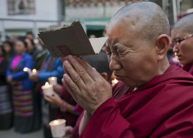 An exile Tibetan nun cries as she prays during a candlelit vigil in solidarity with two Tibetans, who exiles claim have immolated themselves demanding freedom for Tibet, in Dharmsala, India, Wednesday, March 2, 2016. Exiles say that a 16-year-old school boy Dorje Tsering set himself on fire on Tuesday morning in Dehradun and is now being treated for severe burns in New Delhi. (Photo by Ashwini Bhatia/AP Photo)