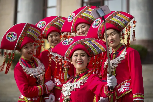 Hostesses, who facilitated the arrival of delegates by bus, pose for a selfie on the steps of the Great Hall of the People during the opening session of China's annual National People's Congress (NPC) in Beijing, Saturday, March 5, 2016. (Photo by Mark Schiefelbein/AP Photo)