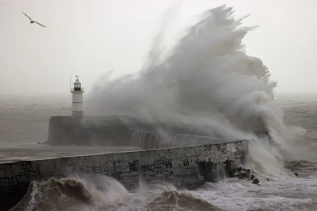 Waves crash over Newhaven Lighthouse and the breakwater in Newhaven on January 2, 2024, as Storm Henk brought strong winds and heavy rain across much of southern England. (Photo by Adrian Dennis/AFP Photo)