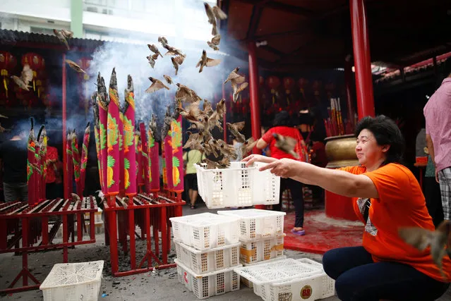 A woman releases birds for good luck during Lunar New Year celebrations at Dharma Bhakti temple in Jakarta, Indonesia January 28, 2017. (Photo by Darren Whiteside/Reuters)