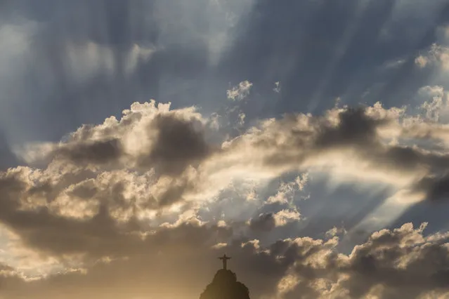 Christ the Redeemer statue is silhouetted against an early evening sky as the sun sets in Rio de Janeiro, Brazil, Wednesday, January 22, 2014. (Photo by Felipe Dana/AP Photo)