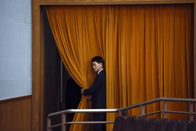 An attendant holds a curtain inside the Great Hall of the People during the second plenary session of the National People's Congress (NPC) in Beijing, China, March 9, 2016. (Photo by Kim Kyung-hoon/Reuters)