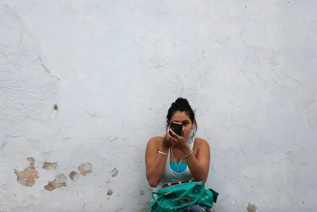 A woman checks her makeup in a compact mirror in downtown Monterrey, Mexico, March 17, 2016. (Photo by Daniel Becerril/Reuters)