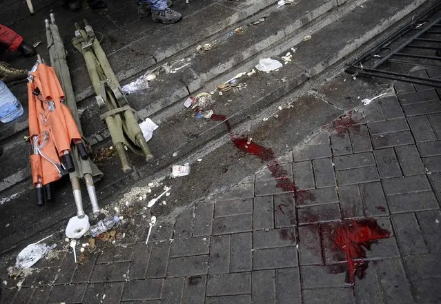 Blood and stretchers are seen on the pavement during clashes with riot police near Independence Square in Kiev February 20, 2014. At least 21 civilians were killed in fresh fighting in Kiev on Thursday, shattering an overnight truce declared by Ukrainian President Viktor Yanukovich, and a presidential statement said dozens of police were also dead or wounded. (Photo by Maks Levin/Reuters)